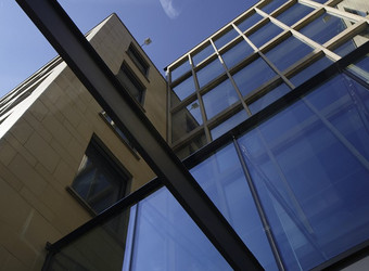 Ansicht Haus der Bayerischen Wirtschaft von unten nach oben fotografiert. Glas, Stahl, Sandstein, Glasfassade, modern, blauer Himmel