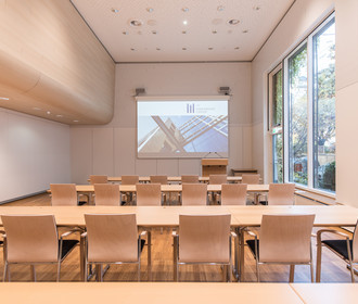 Münchner Saal im Haus der Bayerischen Wirtschaft. Lichtdurchfluteter Raum mit deckenhohen Fenstern. Blick in den Garten